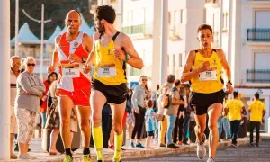 Trzech biegaczy w żółtych i pomarańczowych strojach walczy o zwycięstwo w maratonie. Czy pobiją rekord świata?