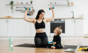 Mama i dziecko ćwiczą z hantlami w kuchni. To świetny przykład na 10 ćwiczeń z hantlami, które można wykonać w domu.