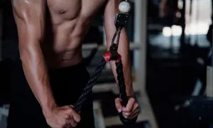 Mięśnie ramion i brzucha podczas wykonywania ćwiczeń na triceps. Skupienie na technice dla najlepszych efektów.