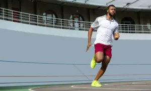 Mężczyzna w sportowym stroju biegnie po bieżni. Zastanawiasz się, jak szybko biega Usain Bolt? Ten zawodnik daje z siebie wszystko!