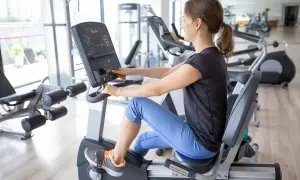 Kobieta ćwiczy na rowerku poziomym, osiągając świetne efekty.
