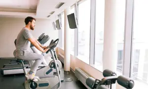 Mężczyzna ćwiczy na rowerze stacjonarnym, który może być dobrym wyborem, jeśli zastanawiasz się, jaki rower stacjonarny do rehabilitacji kolana wybrać.