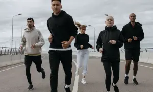 Grupa biegaczy w sportowych ubraniach, idealnych na 10 stopni. Lekkie bluzy i spodnie zapewniają komfort podczas treningu.