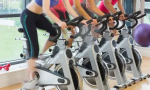 Ludzie ćwiczą na rowerach stacjonarnych. Zastanawiasz się, jaki rower stacjonarny kupić?