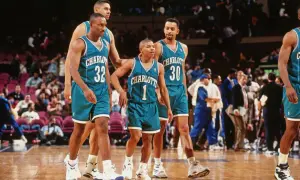 Koszykarze Charlotte Hornets, w tym najniższy koszykarz NBA, w turkusowych strojach na boisku.