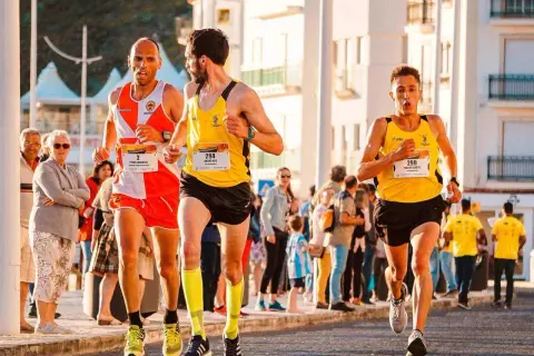 Trzech biegaczy w żółtych i pomarańczowych strojach walczy o zwycięstwo w maratonie. Czy pobiją rekord świata?