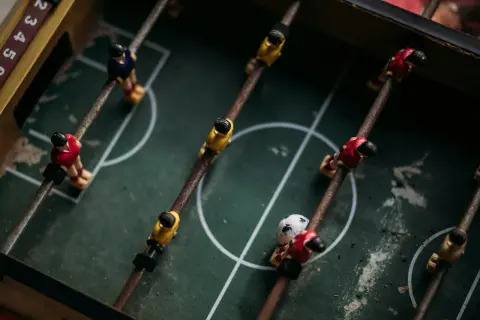 Stare figurki na stole do piłkarzyków, gotowe do gry. Każdy gracz marzy, by zostać legendą futbolu.