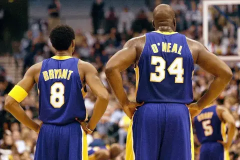 Kobe Bryant (8) i Shaquille O'Neal (34) w strojach Lakersów, czekają na rozpoczęcie meczu. Ile trwa mecz koszykówki? Zwykle 4 kwarty po 12 minut.