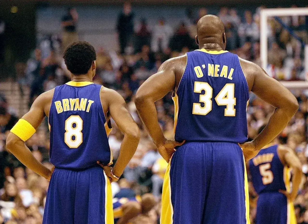 Kobe Bryant (8) i Shaquille O'Neal (34) w strojach Lakersów, czekają na rozpoczęcie meczu. Ile trwa mecz koszykówki? Zwykle 4 kwarty po 12 minut.