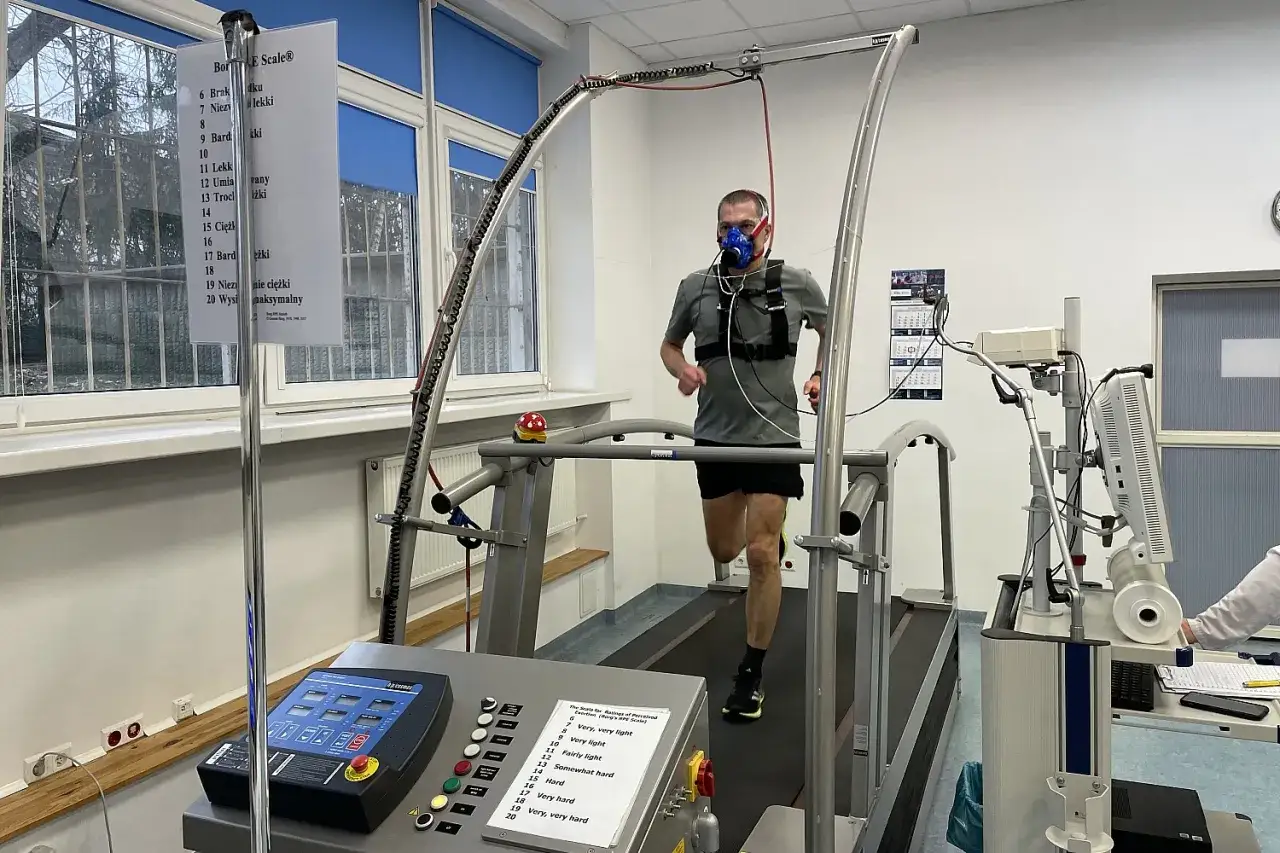 Mężczyzna w masce biegający na bieżni podczas testu wysiłkowego, mającego na celu określenie jego VO2max.