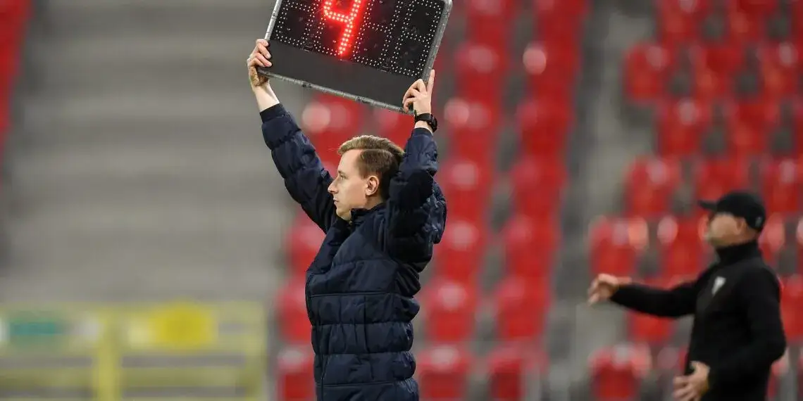 Sędzia piłkarski pokazuje doliczony czas gry na tablicy