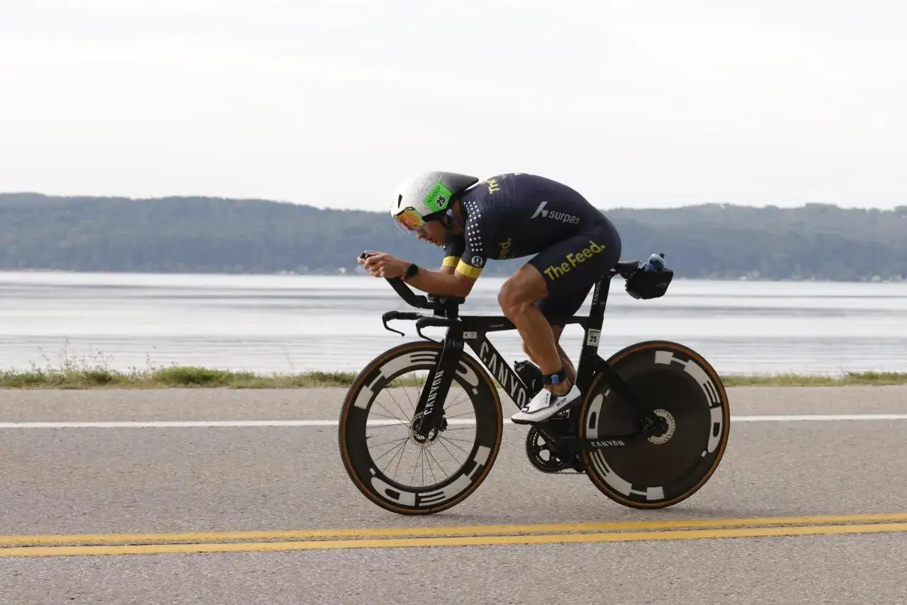 Zawodnik w stroju kolarskim na rowerze czasowym, pokonujący etap kolarski w ramach triathlonu. To właśnie triathlon co to za dyscyplina!