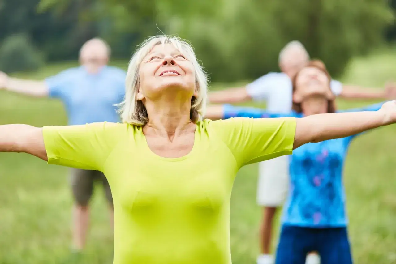 Seniorzy ćwiczą tai chi na trawie. Choć tai chi ma wiele zalet, warto znać jego tai chi przeciwwskazania, by ćwiczyć bezpiecznie.