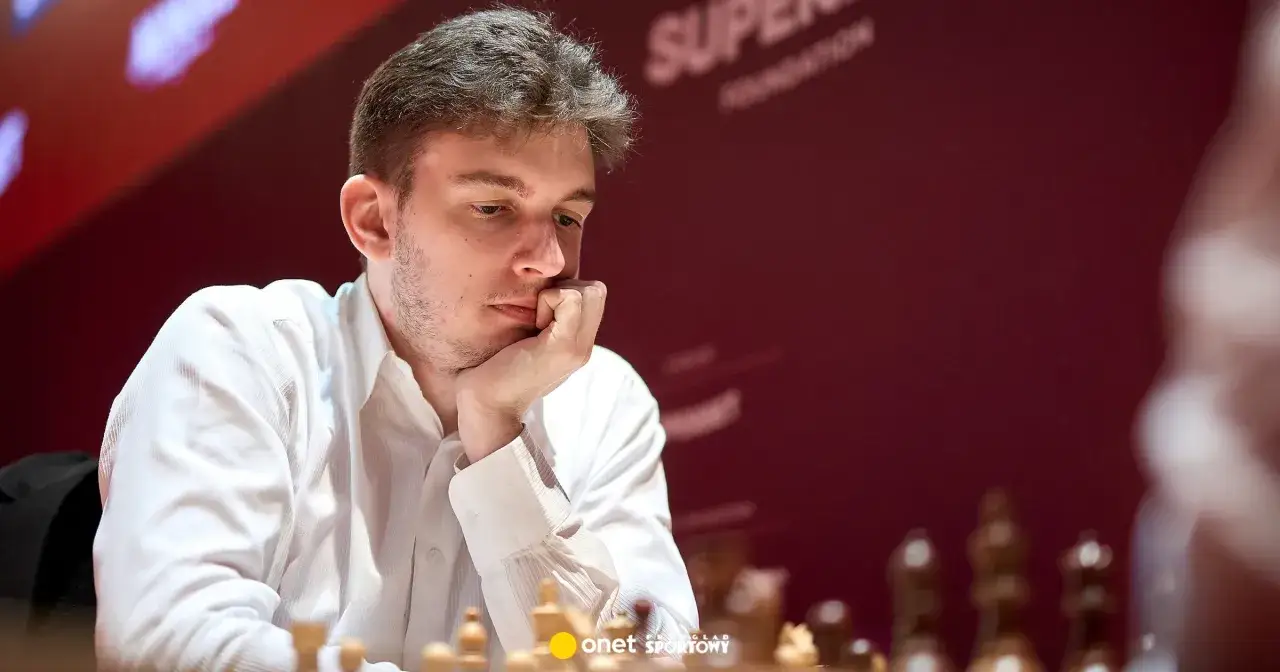 Młody grandmaster Jan Krzysztof Duda zamyślony nad szachownicą.