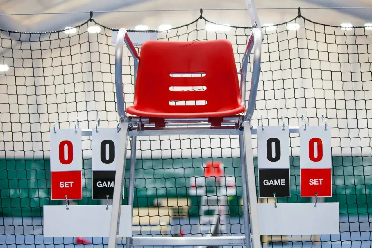 Sędziowskie krzesło z tablicami wyników: 0:0 w setach i gemach. Początek meczu, zasady gry w tenisa ziemnego jasne.