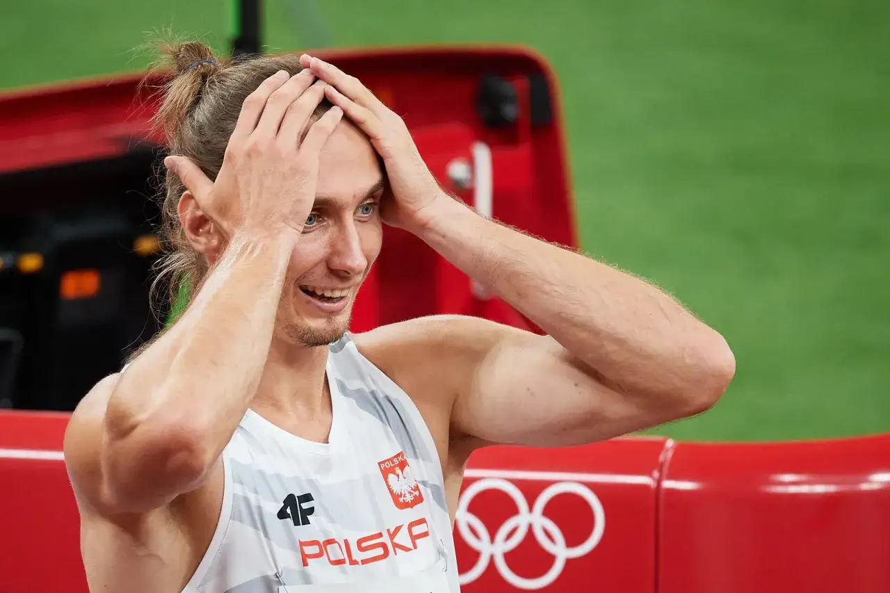 Zwycięzca biegu na 400 m, z rękami na głowie, świętuje swój nowy rekord Polski.
