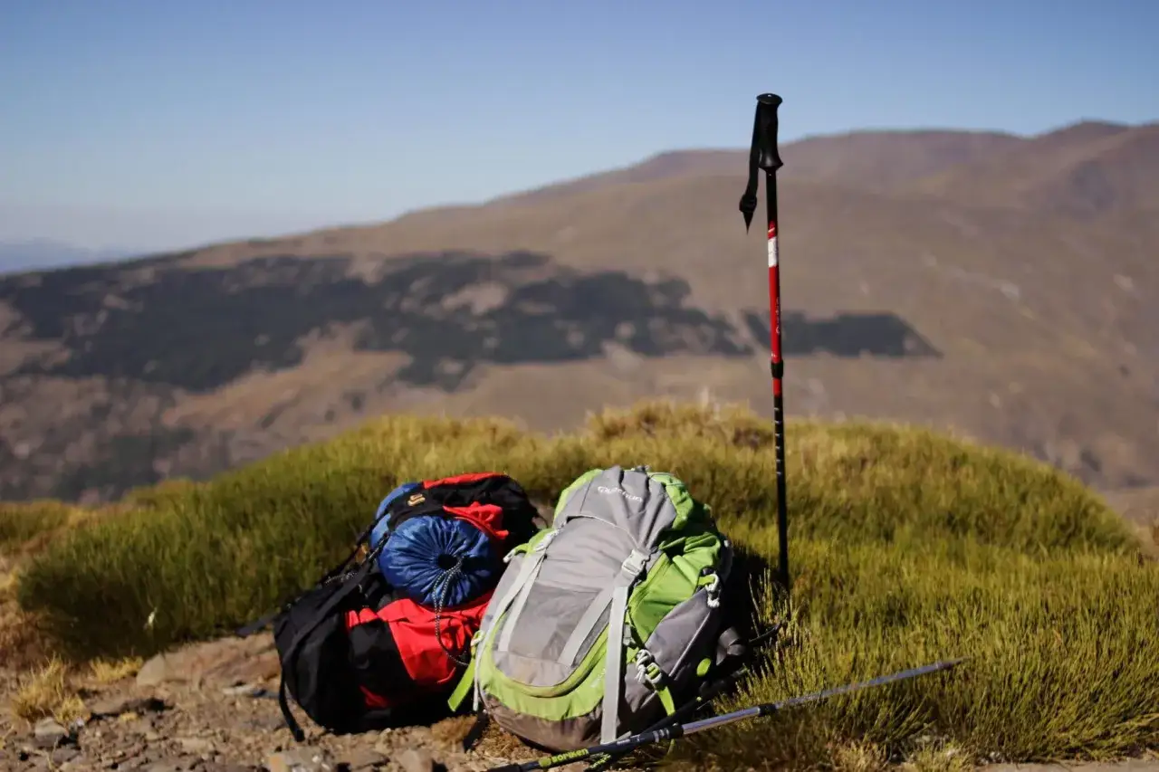 Plecak i kijki trekkingowe czekają na wyprawę. To właśnie trekking, czyli wędrówka po górach, pozwala odkrywać takie widoki.