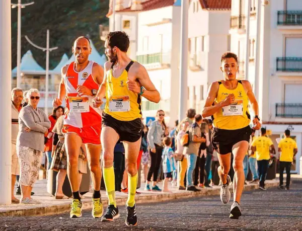 Trzech biegaczy w żółtych i pomarańczowych strojach walczy o zwycięstwo w maratonie. Czy pobiją rekord świata?