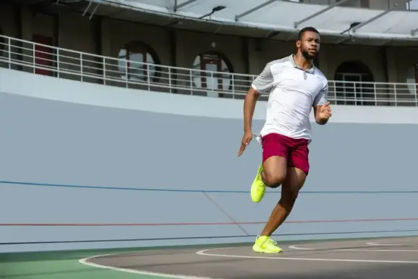 Mężczyzna w sportowym stroju biegnie po bieżni. Zastanawiasz się, jak szybko biega Usain Bolt? Ten zawodnik daje z siebie wszystko!