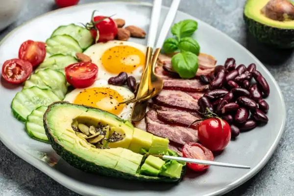 Talerz z jajkami sadzonymi, boczkiem, fasolą, awokado i warzywami. Czy dieta keto jest zdrowa?