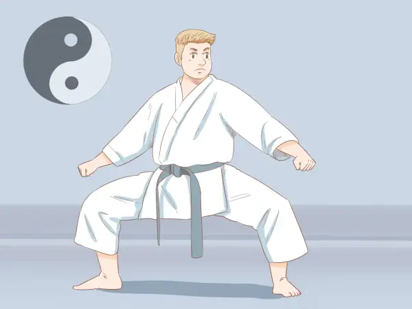 Chłopiec w białym karate gi, z szarym pasem, w pozycji bojowej. Obok symbol Yin i Yang. Poznaj nazwy sztuk walki.